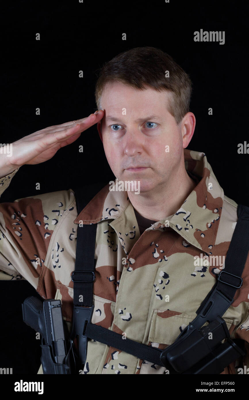 L'immagine verticale di militari soldato maschio salutando mentre armata con sfondo nero. Foto Stock
