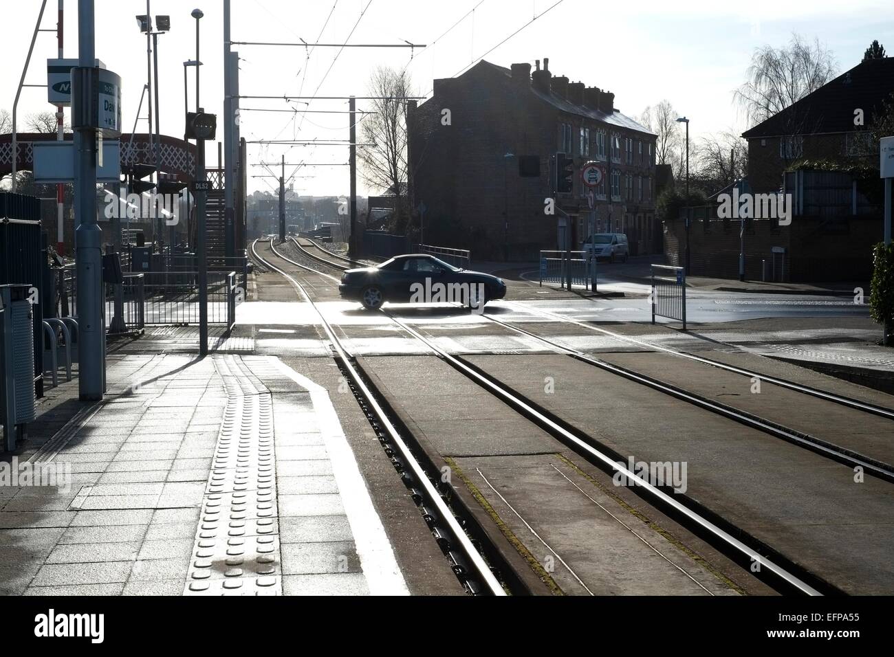 Il passaggio di un auto rispetto a David lane tram e incrocio ferroviario Basford, Nottingham. In Inghilterra. Regno Unito. Foto Stock