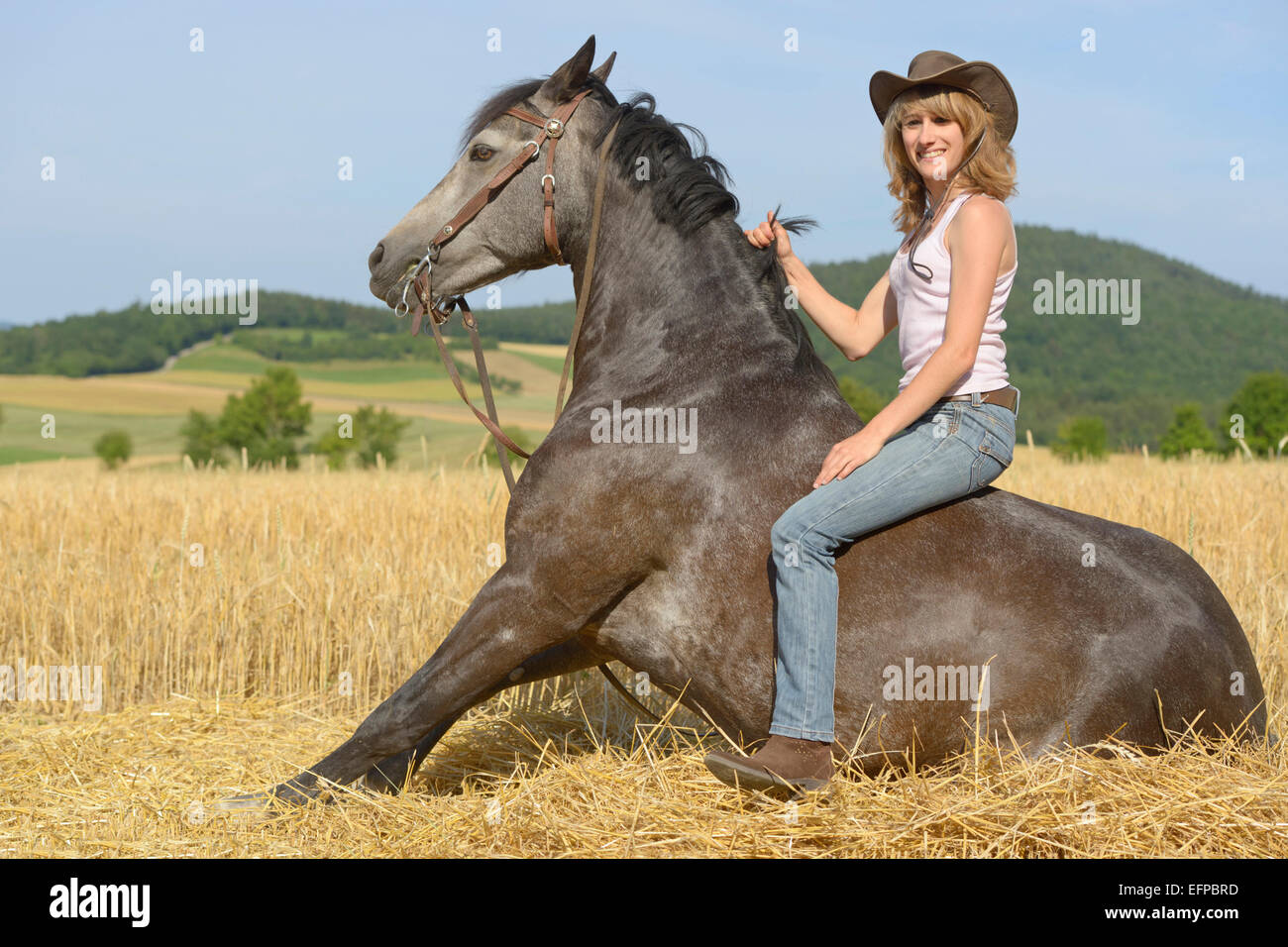 Sorridente giovane donna seduta bareback lei stabilite pony Connemara ermany Foto Stock
