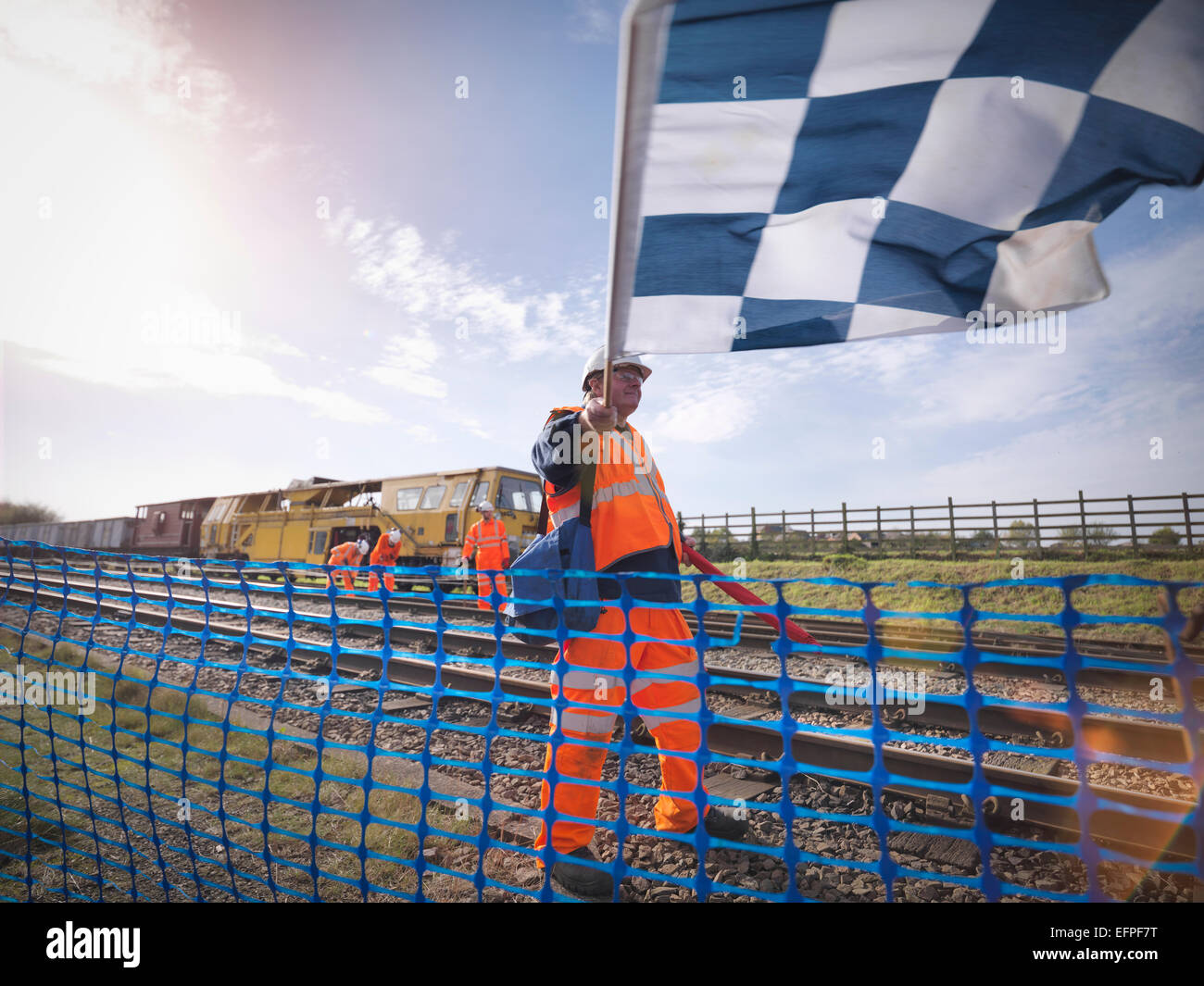 Manutenzione ferroviaria lavoratore sventola bandiera sul binario ferroviario Foto Stock