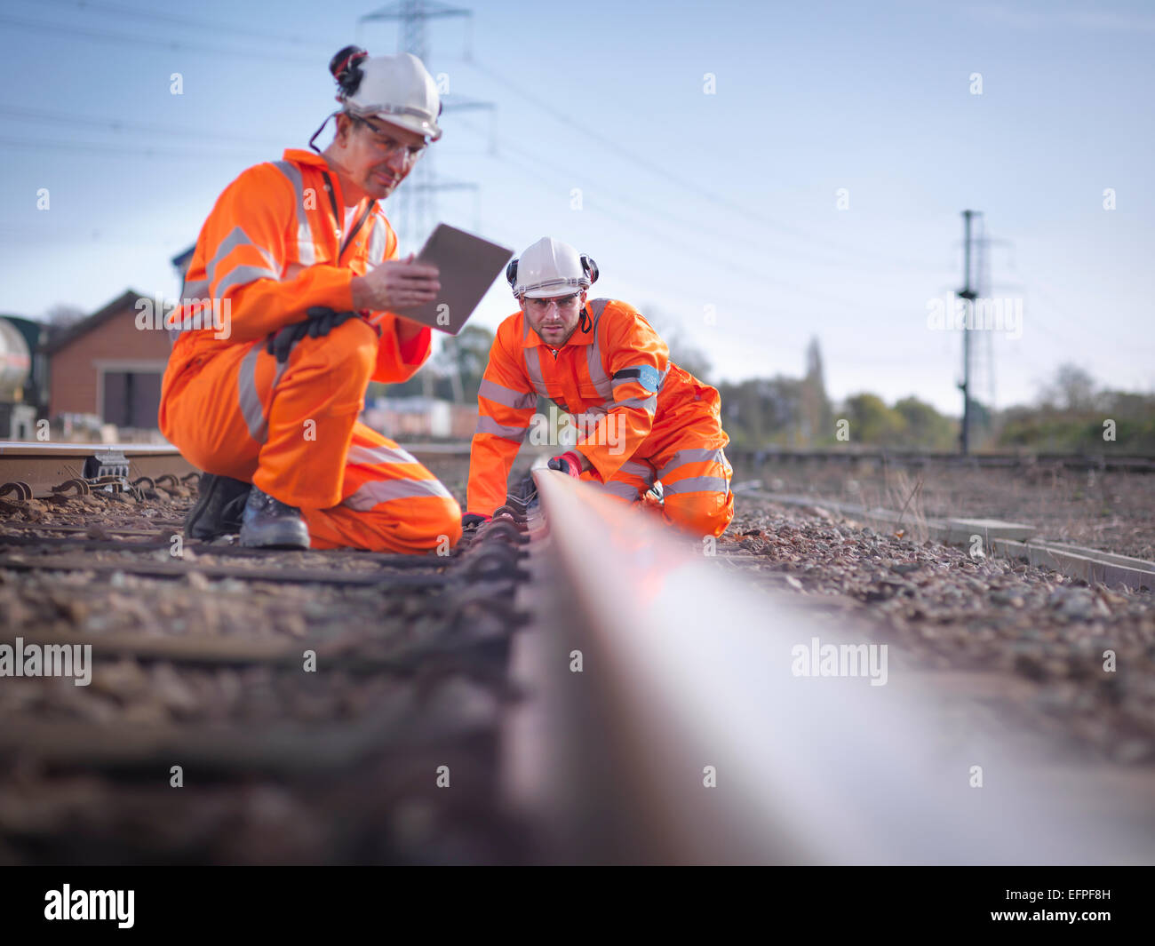 Manutenzione ferroviaria lavoratori con tavoletta digitale per ispezionare la via Foto Stock