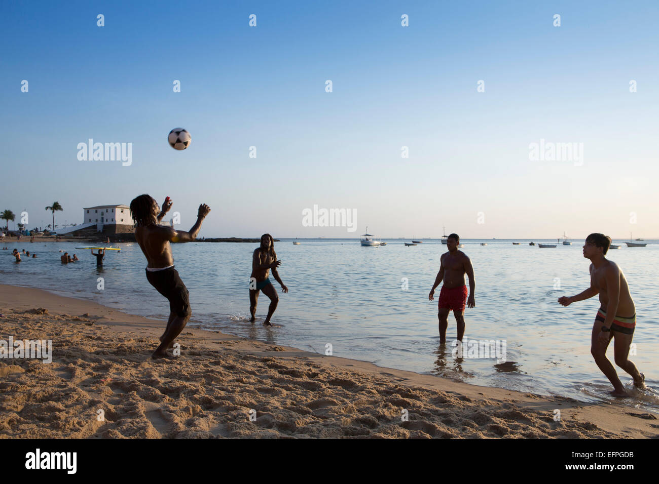 La gente del posto che giocano a calcio sulla barra beach, Salvador, Bahia, Brasile, Sud America Foto Stock