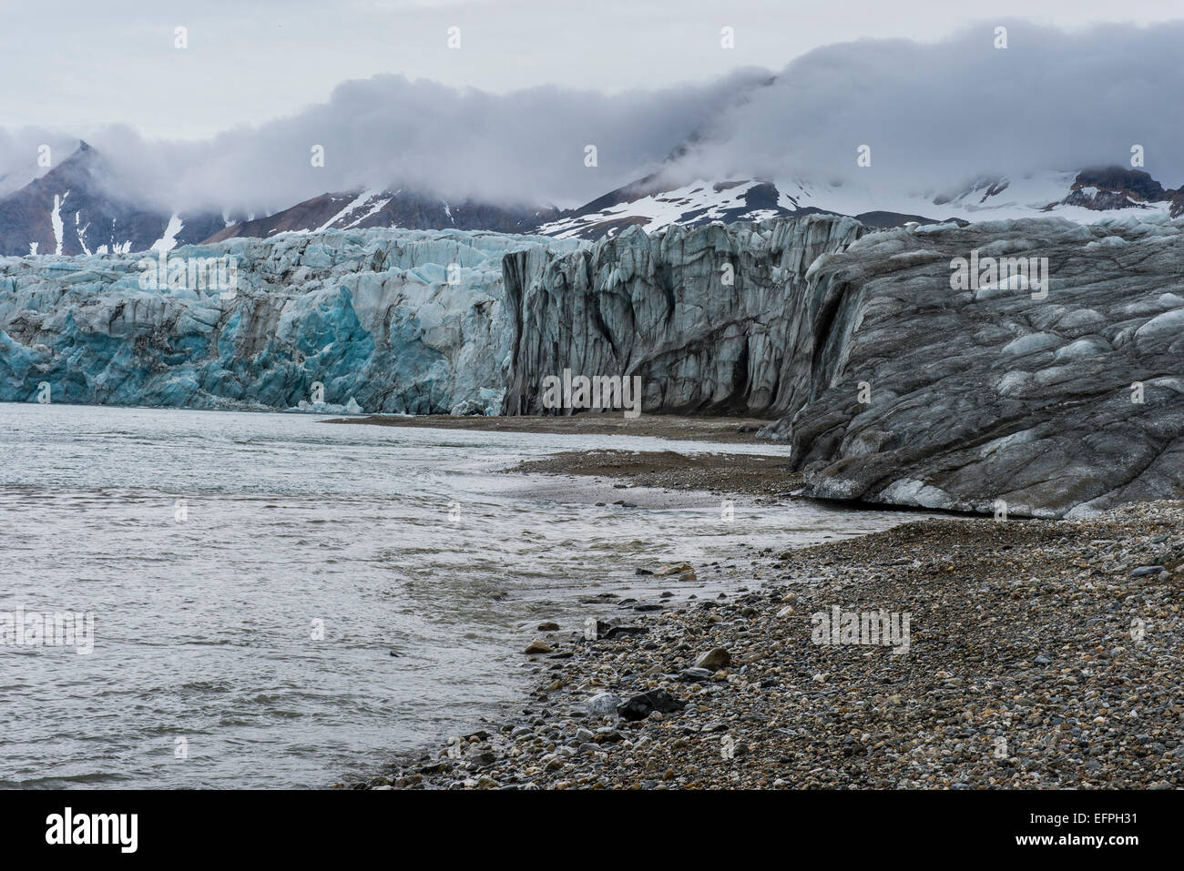 Spiaggia di ghiaia prima di un enorme ghiacciaio in Hornsund, Svalbard, Arctic Foto Stock