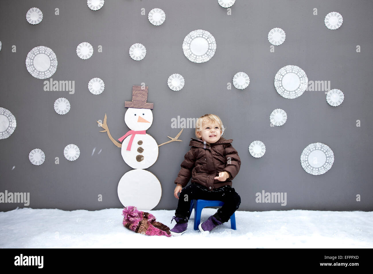 Bambina con il simbolo del fiocco di neve e pupazzo di ritagli Foto Stock