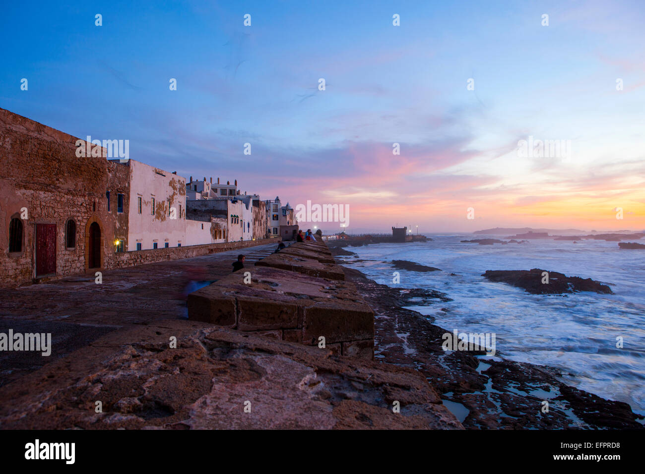 Le mura della città e il lungomare al tramonto, Essaouira, Marocco Foto Stock