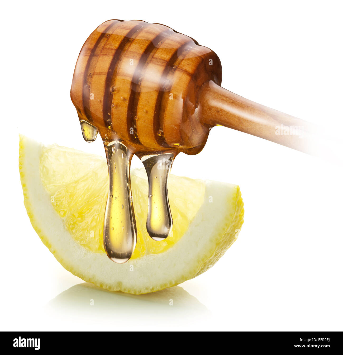 Miele con bastone di legno versare su una fetta di limone. Sfondo bianco. Foto Stock