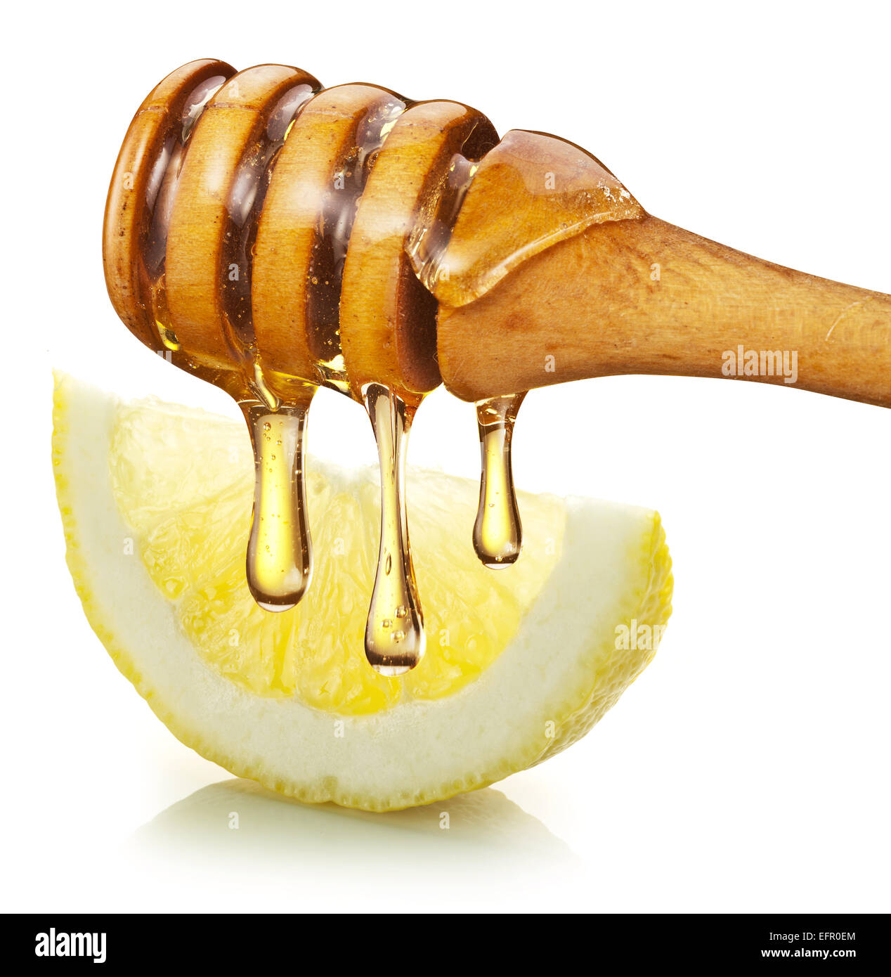 Miele con bastone di legno versare su una fetta di limone. Sfondo bianco. Foto Stock