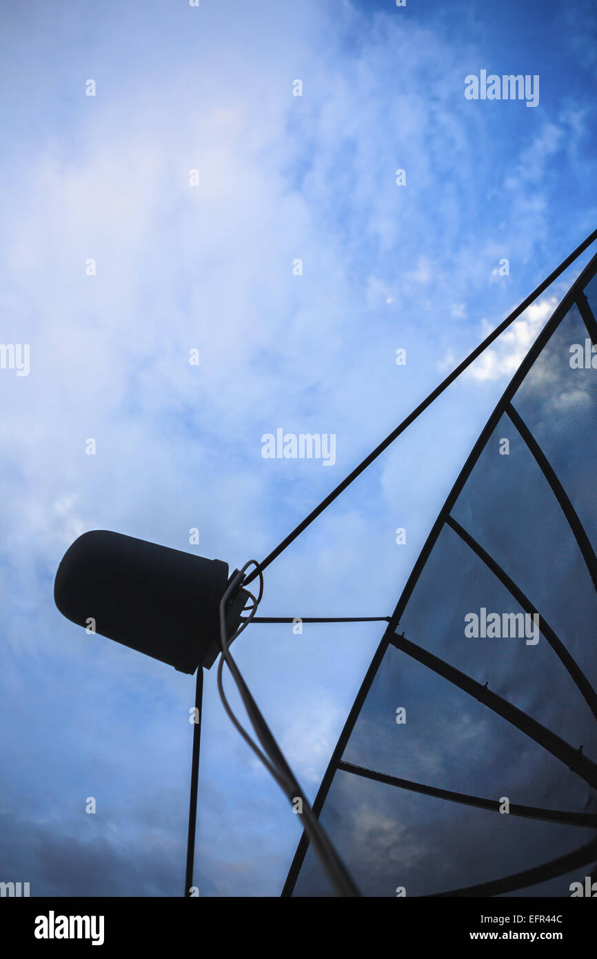 Nero a doppia parabola satellitare contro blu cielo nuvoloso la mattina presto Foto Stock