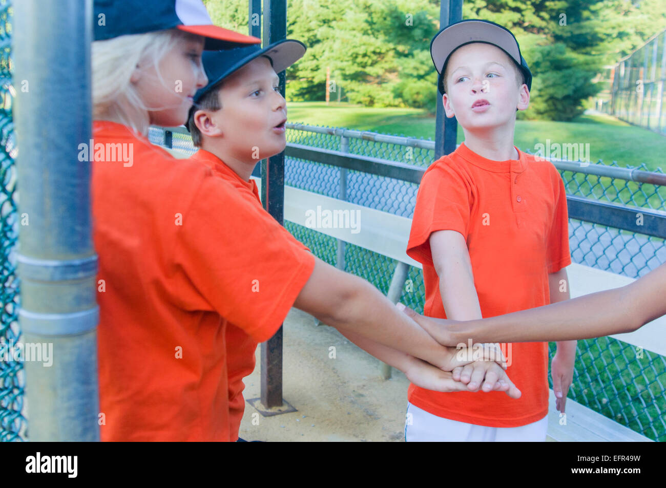 I giovani giocatori di baseball di toccare le mani Foto Stock