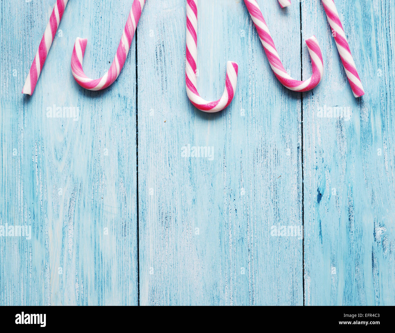 Candy Canes sul vecchio blu sullo sfondo di legno. Foto Stock
