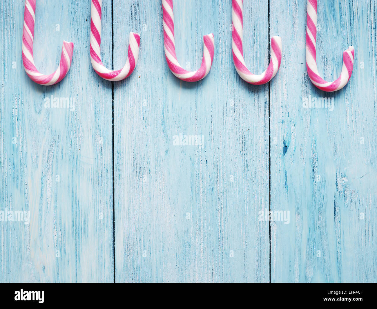 Candy canes sul vecchio blu sullo sfondo di legno. Foto Stock