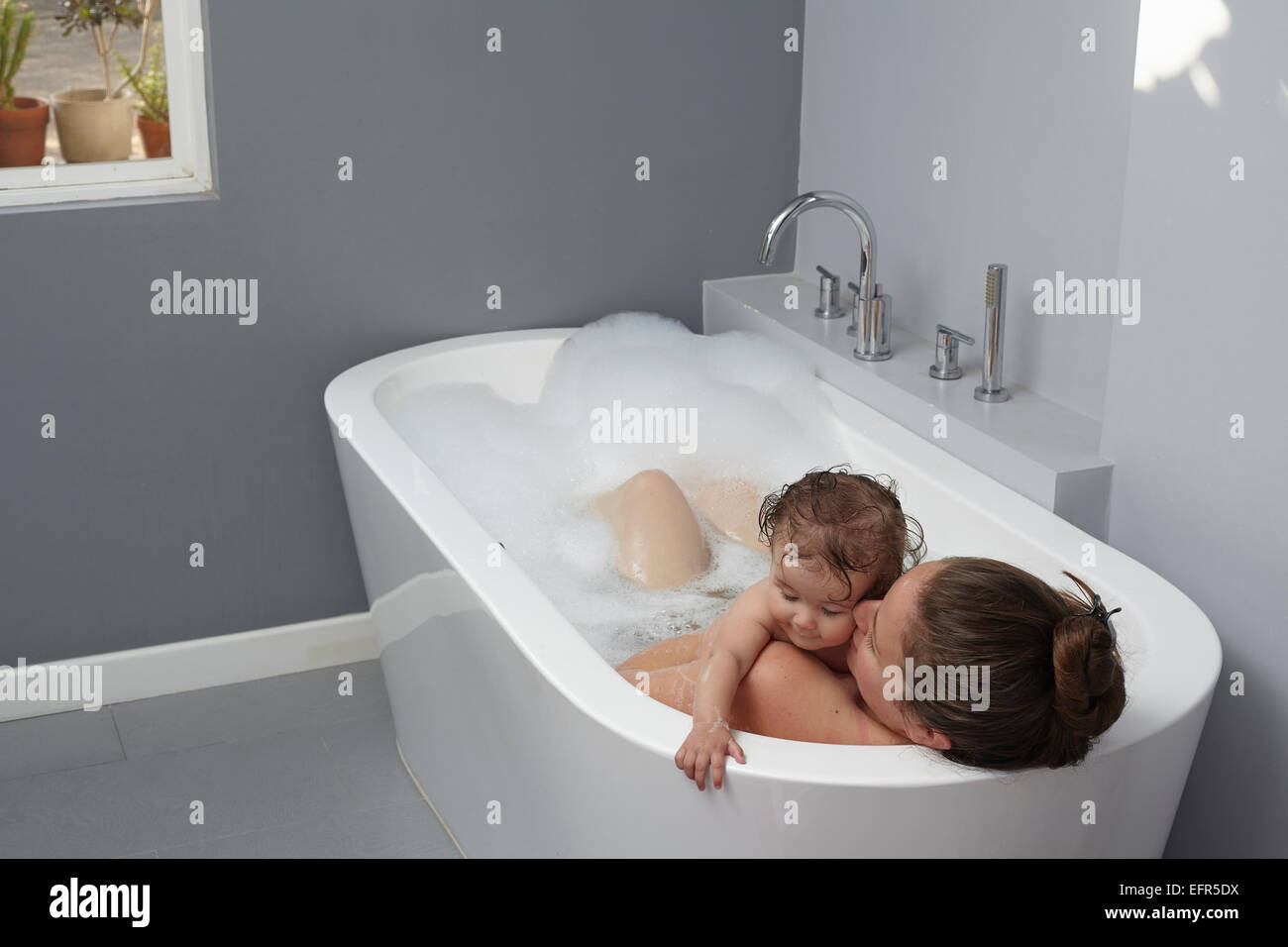 La madre e il bambino ragazza nella vasca da bagno Foto Stock