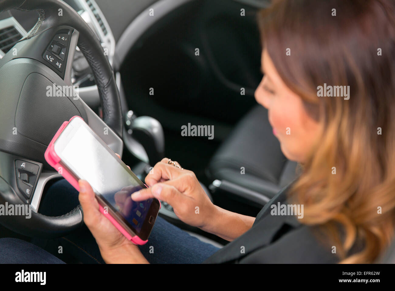 Business donna utilizza lo smartphone in auto Foto Stock