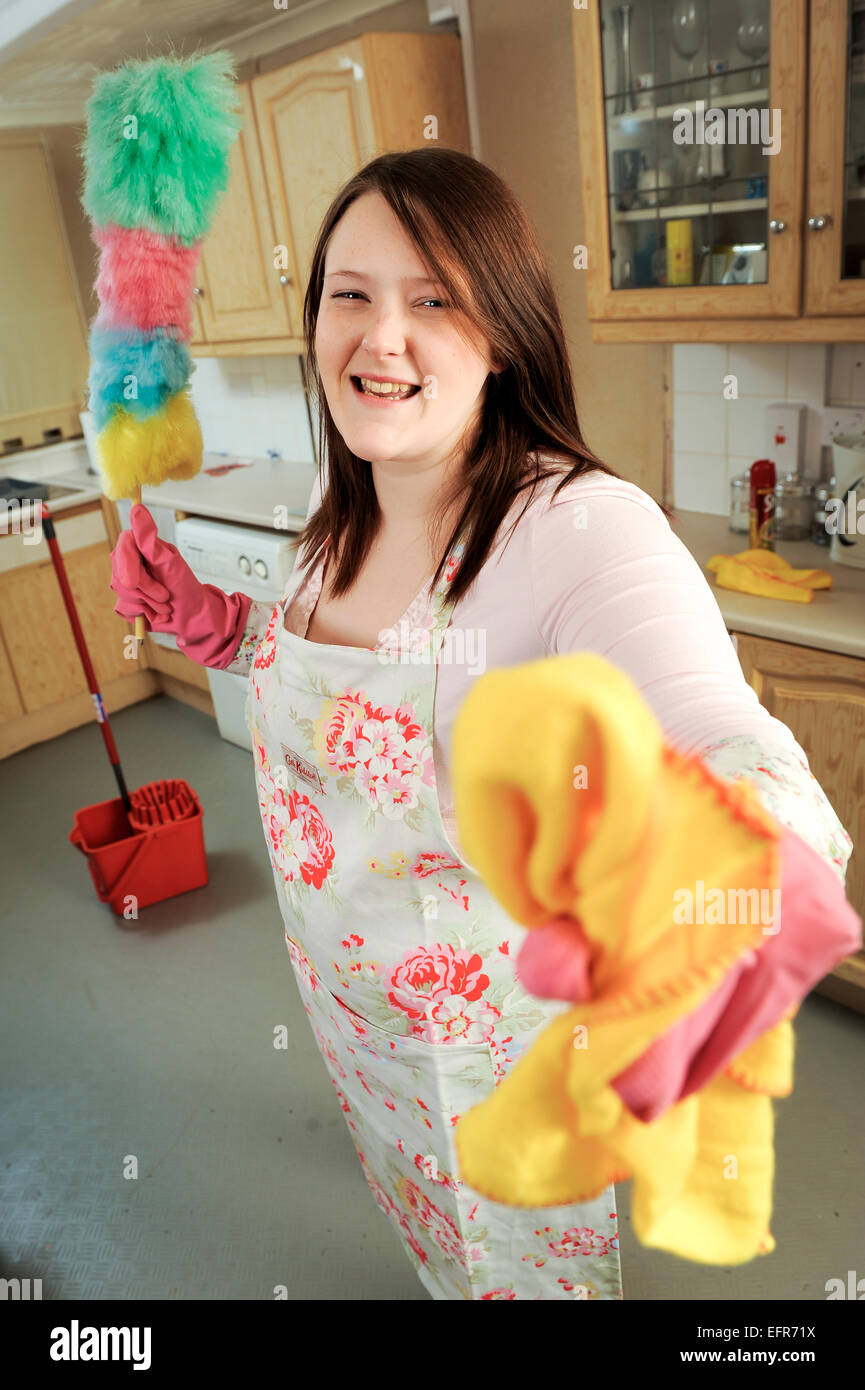 Giovane donna di casa pulizia moglie la sua cucina. Spandimento sul pavimento e la lucidatura della tabella e generali di ordine e pulizia e spolvero. Foto Stock