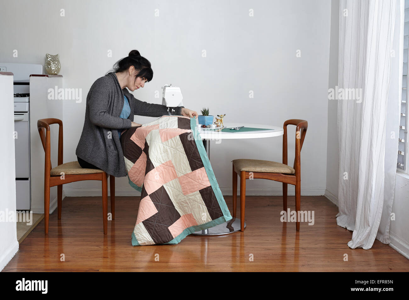 Donna fare quilt sulla macchina per cucire a casa Foto Stock