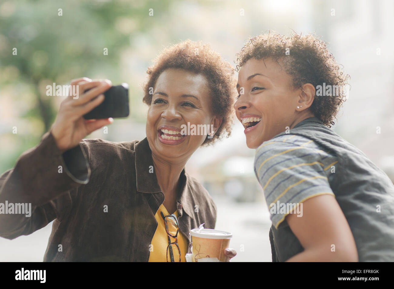 Due femmina matura amici prendendo selfie dello smartphone su strada Foto Stock