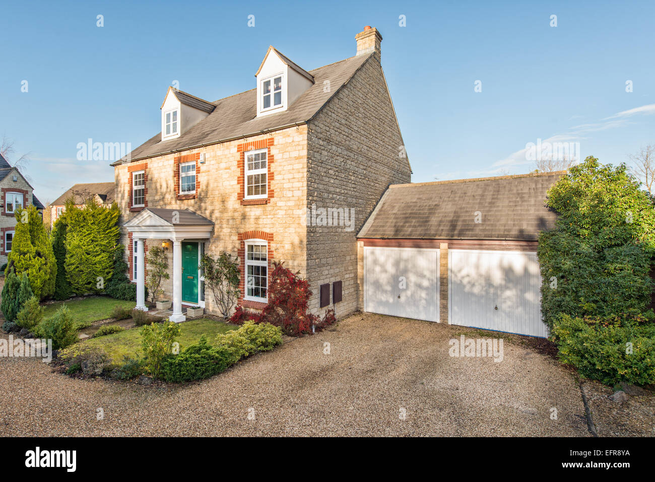 Un moderno tipico sviluppatore suburbana costruita casa & garage su uno sviluppo in Faringdon, Oxfordshire, Regno Unito su un soleggiato sumer sera Foto Stock