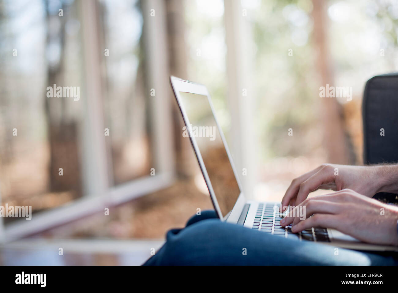 Close up di un uomo con le mani in mano, la digitazione sul suo computer portatile. Foto Stock