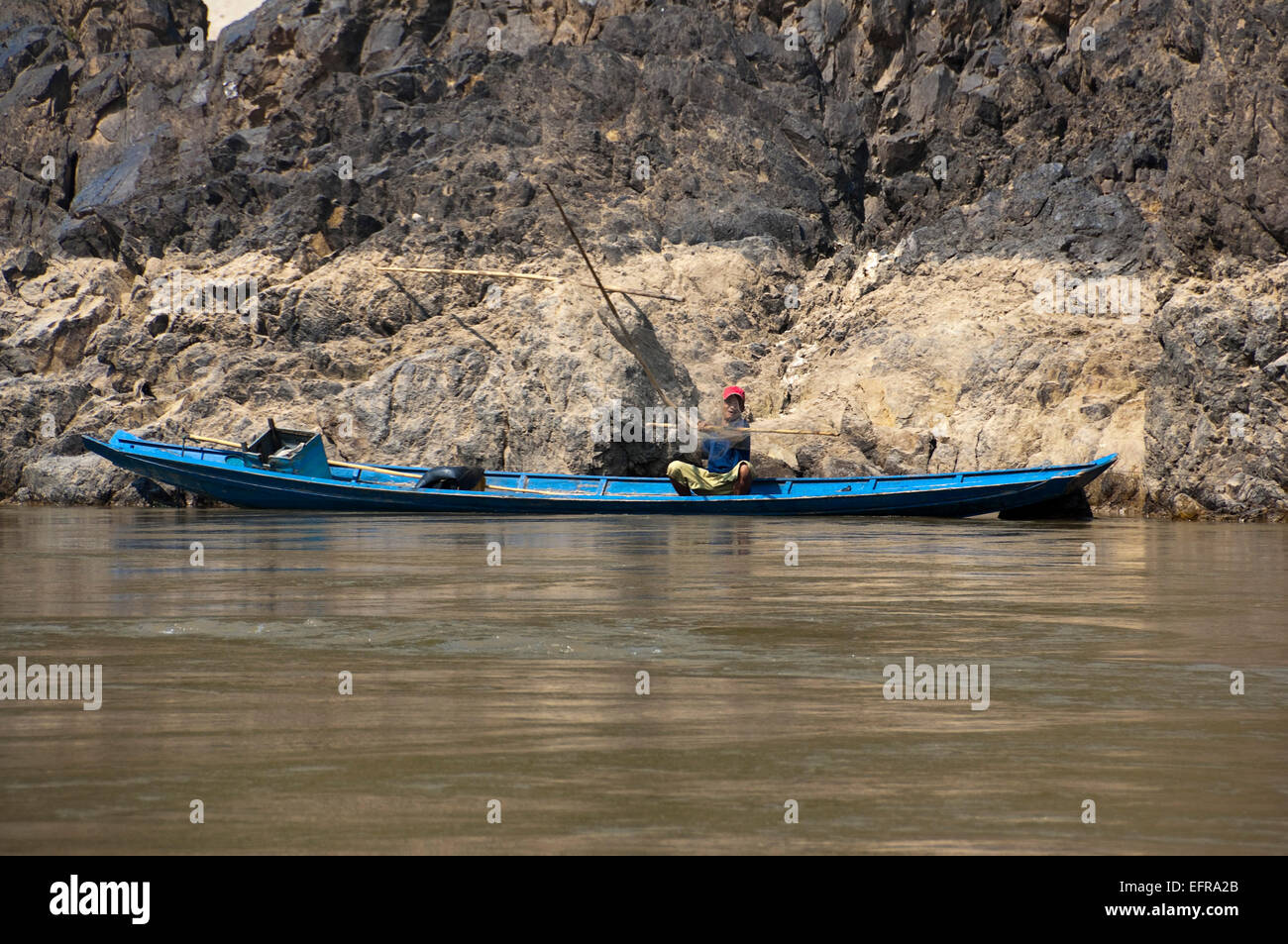 Vista orizzontale di un locale Lao uomo in pesca dalla sua barca sul fiume Mekong. Foto Stock
