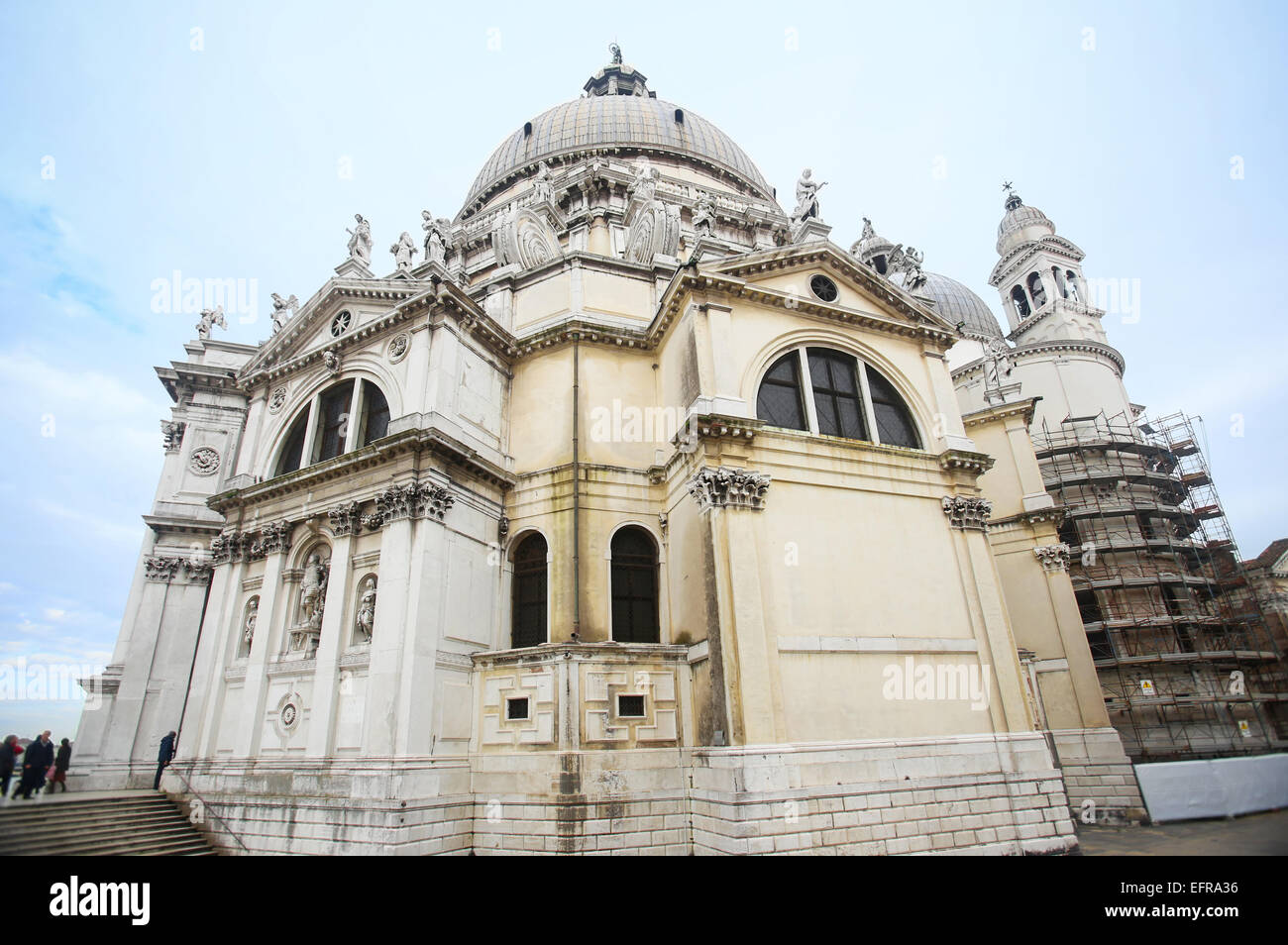 Un basso angolo di visione della chiesa di Santa Maria della Salute, e la gente di visite a Venezia, Italia. Foto Stock