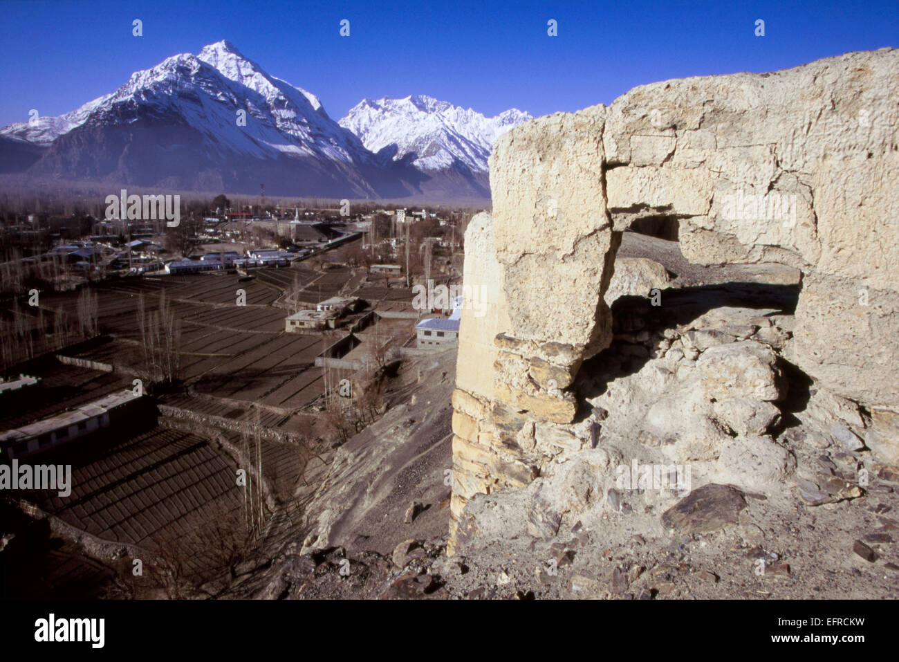 Fatiscenti rovine del tempio a Skardu con enormi picchi della gamma del Karakorum dietro Foto Stock