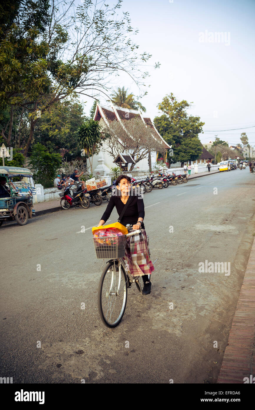 Donna su una bicicletta, Luang Prabang, Laos. Foto Stock