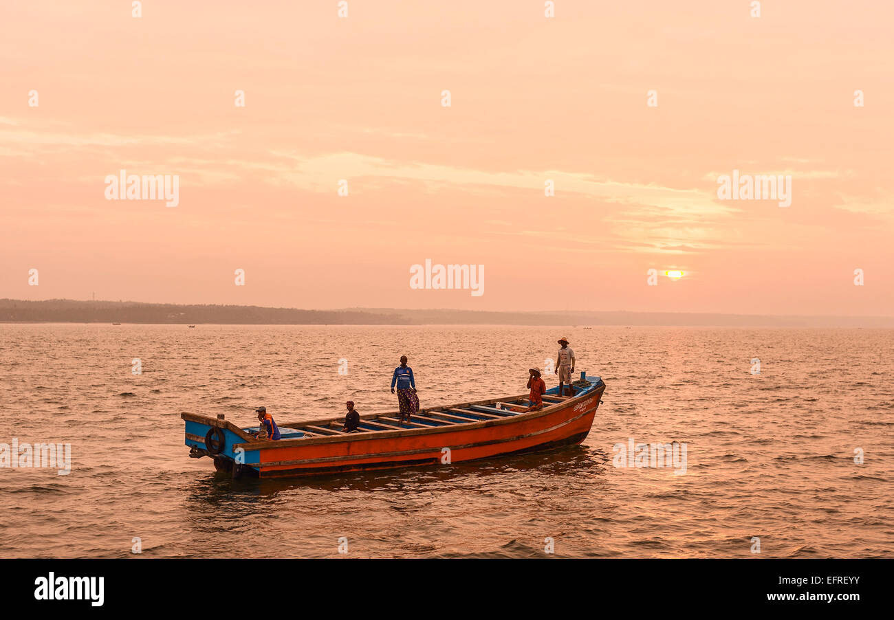 I pescatori in una barca di legno tradizionale per mare su un viaggio di pesca a sunrise off la Costa di Malabar. Foto Stock