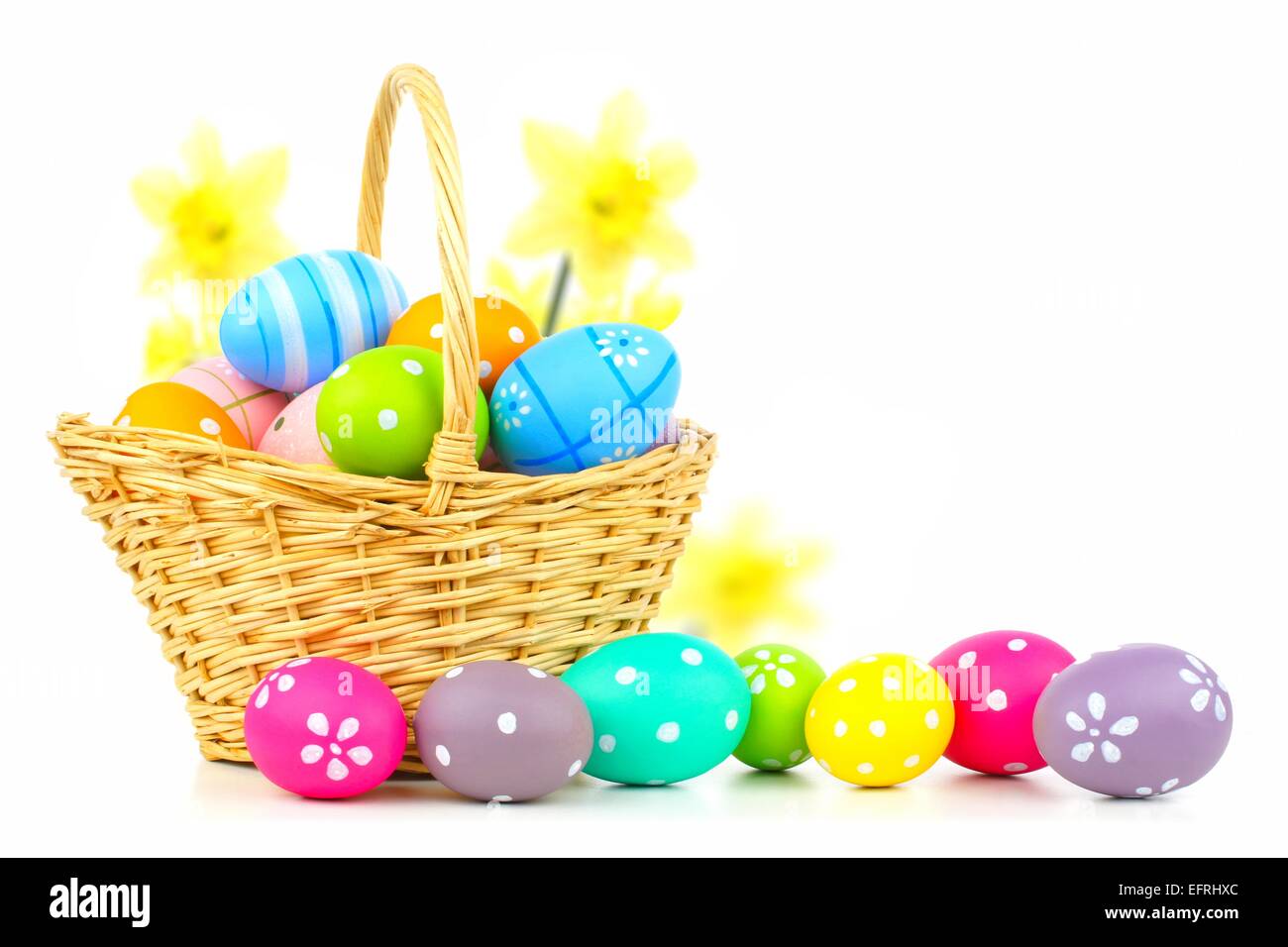 Pasqua cesto pieno di uova colorate su sfondo bianco Foto Stock