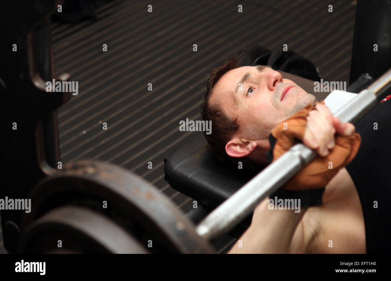 Bodybuilding allenamento in palestra. Maschio di sollevamento pesi gratuiti di formazione utilizzando pecks barbell. Foto Stock