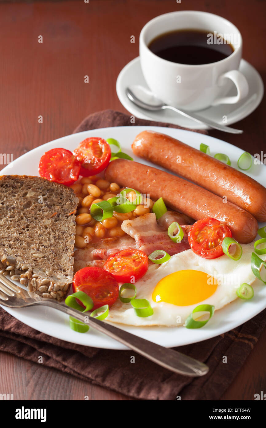 Prima colazione inglese con uovo fritto salsicce pancetta fagioli pomodori Foto Stock