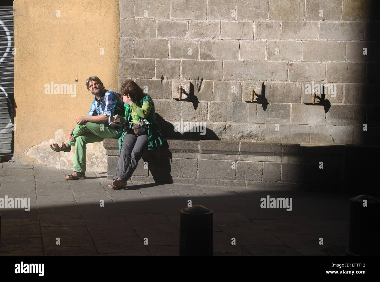 I turisti seduti a bere fontana nel Quartiere Gotico (Barrio Gotico), Barcellona, in Catalogna, Spagna Foto Stock