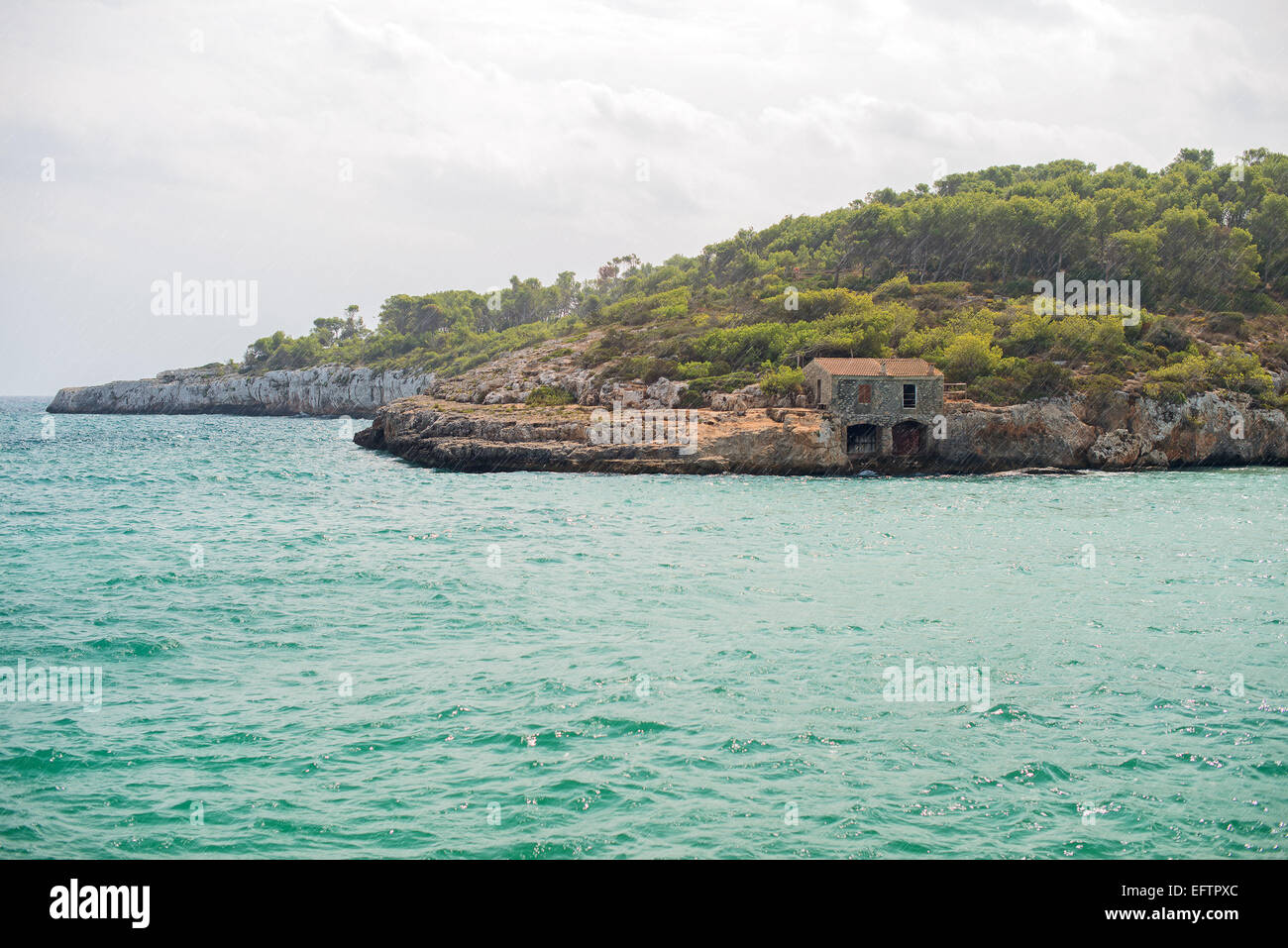 La pioggia sulla spiaggia con lodge di pesca. Foto Stock