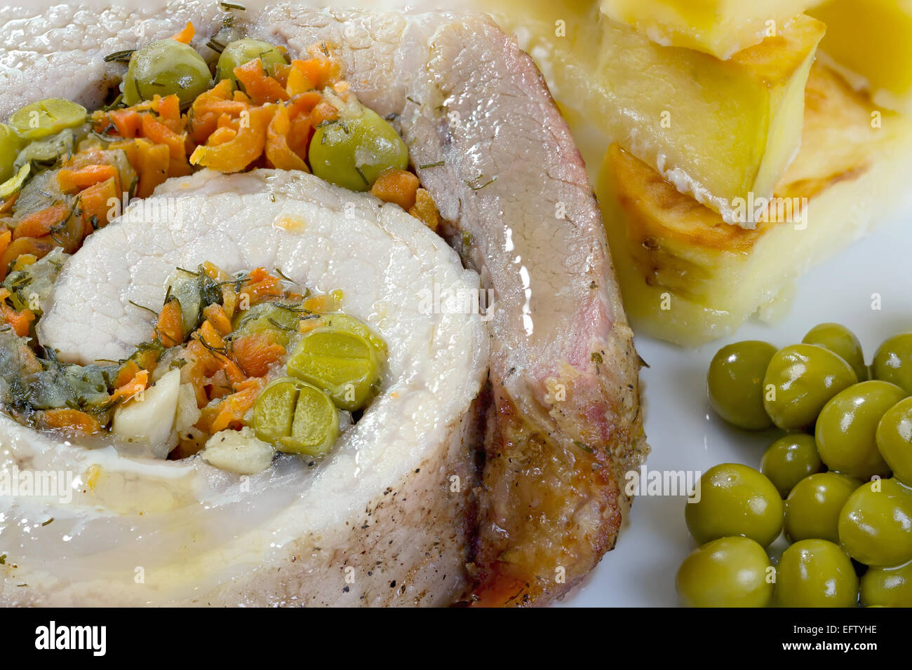 Vista da vicino di casa polpettone con patate arrosto e piselli verdi. Foto Stock