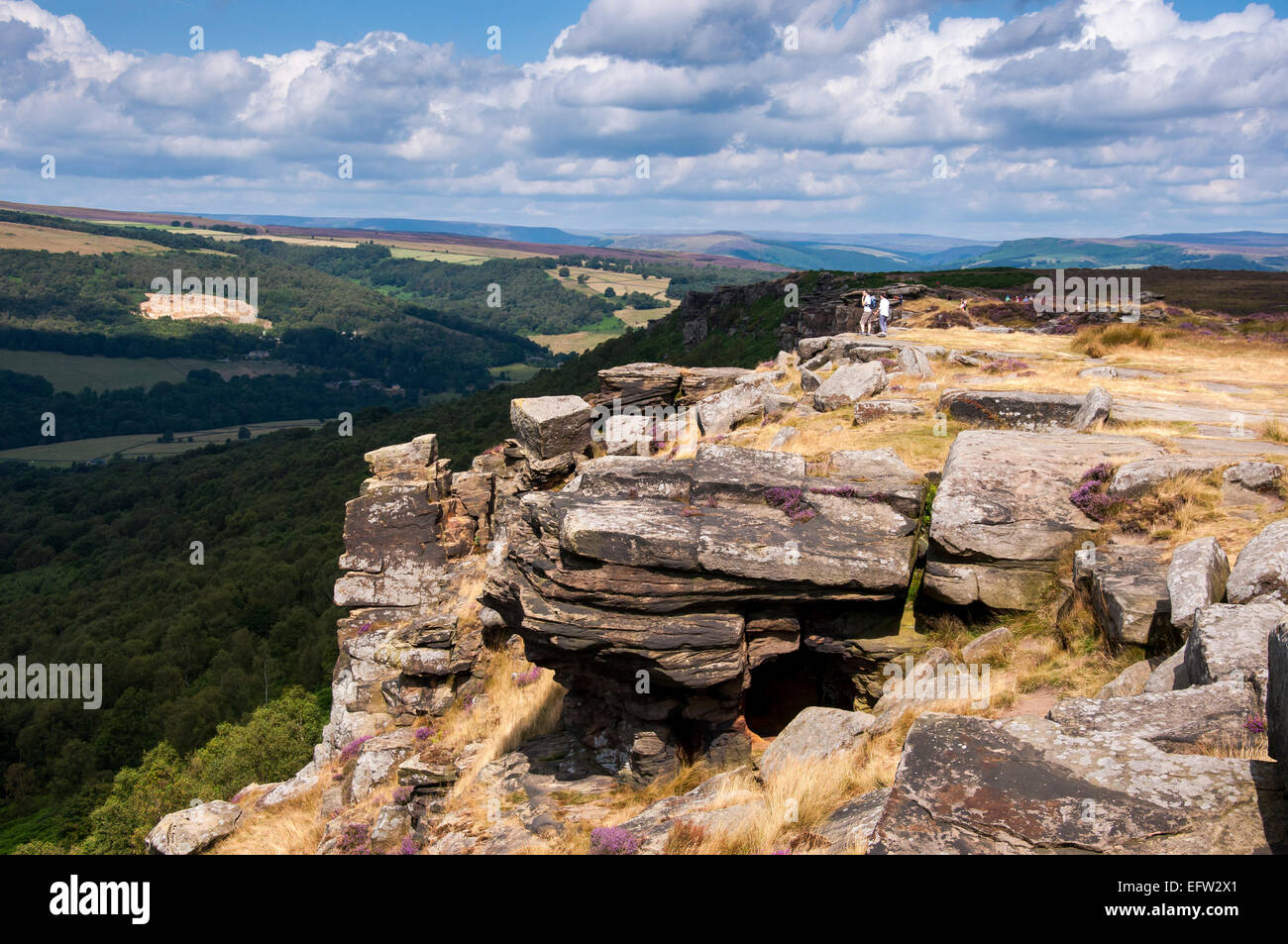 La luce del sole sul bordo Curbar nel Peak District. Una piccola grotta sul bordo. Foto Stock