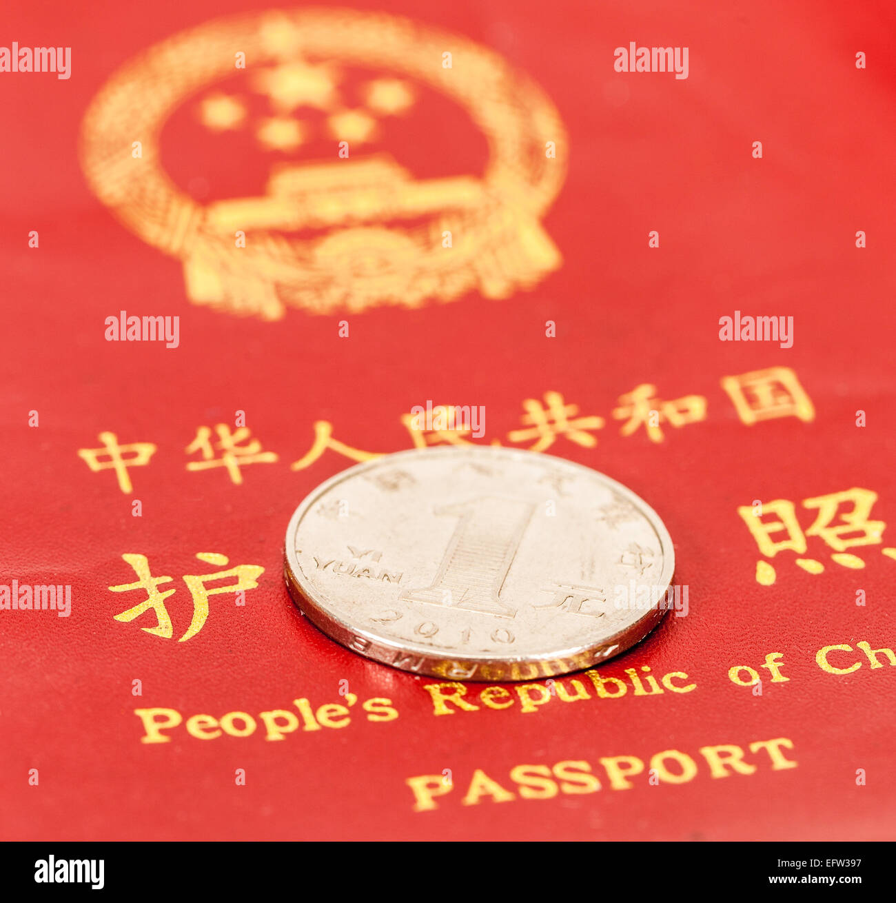 Uno cinese Yuan moneta contro lo sfondo del passaporto cinese Foto Stock