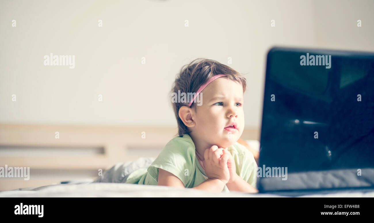 Bambina guardare cartoni al laptop Foto Stock