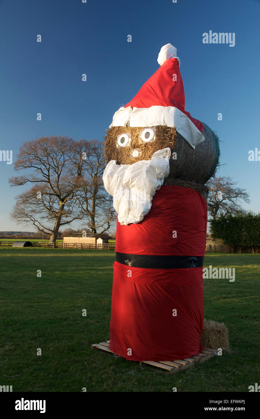 Happy Xmas. Un grande comico la figura di Santa Claus fatta di balle di fieno. Si tratta di un eccentrico il tempo di Natale nella campagna di Dorset. Inghilterra, Regno Unito Foto Stock