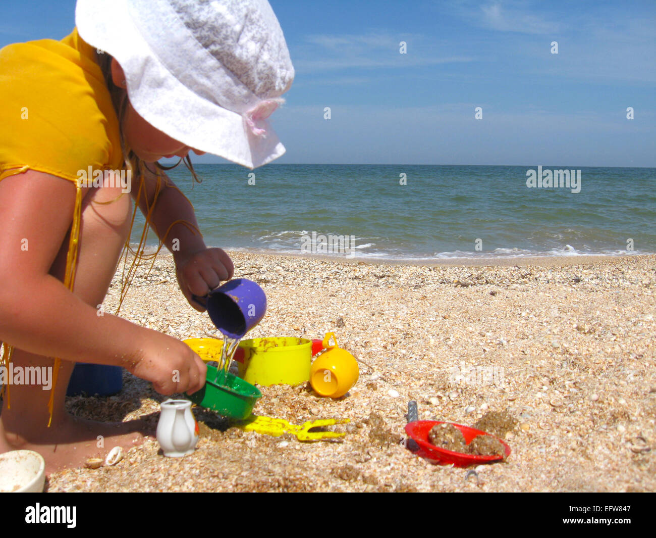 Bambina gioca sulla sabbia al mare Foto Stock