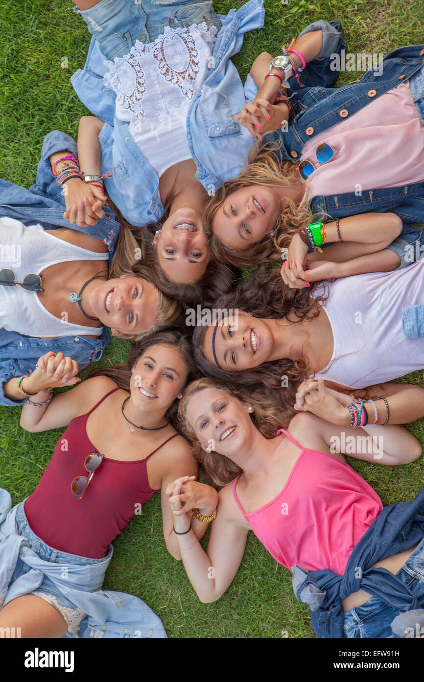 Felice teen ragazze in cerchio per mano e sorridente Foto Stock