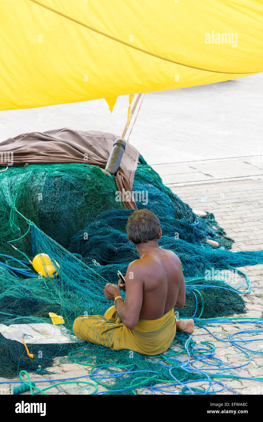 Fisherman riparazione di reti da pesca. Porta Mirissa, Mirissa, sud della provincia, Sri Lanka. Foto Stock