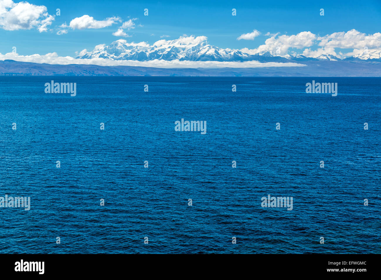 Vista delle montagne delle Ande con il profondo blu del lago Titicaca in primo piano Foto Stock