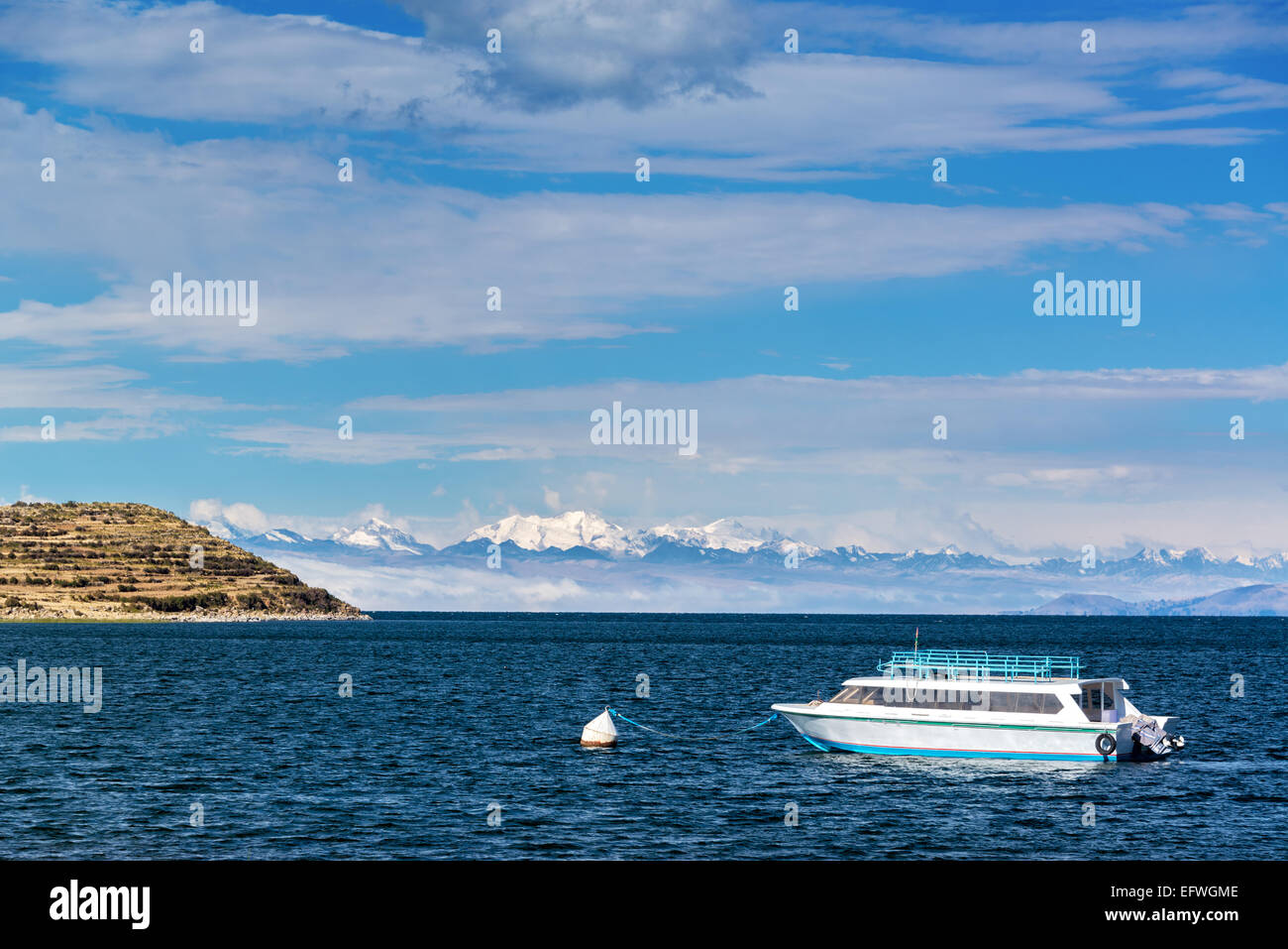 Vista di una barca sul lago Titicaca con montagne delle Ande in background come si vede da Isla del Sol in Bolivia Foto Stock