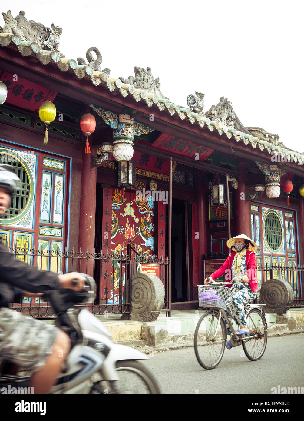 Donna Bicicletta Equitazione dalla Quan Cong tempio (Chua ONGS), Hoi An, Vietnam. Foto Stock