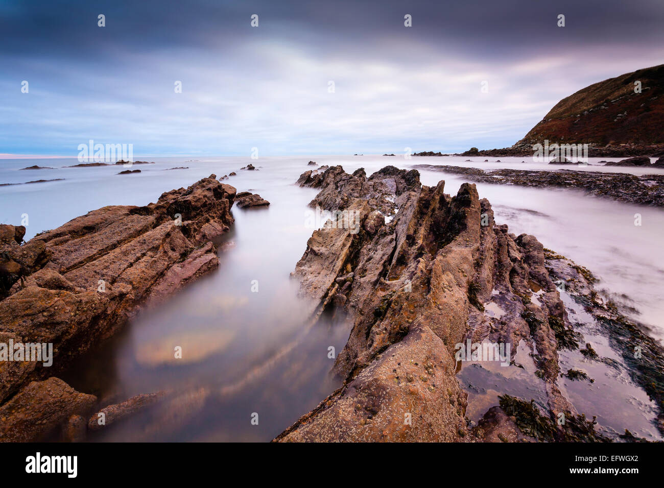 Parallelamente le rocce dietro Cove Harbour in confini scozzesi all'alba. Foto Stock