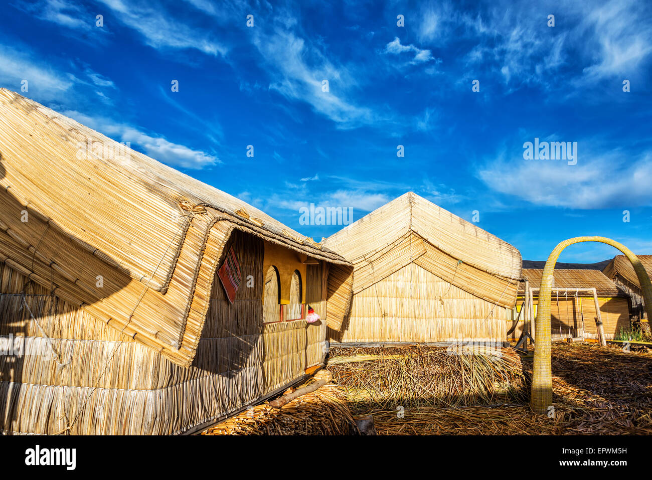 Piccole case su Uros isole galleggianti fatte di canne sul lago Titicaca vicino a Puno, Perù Foto Stock