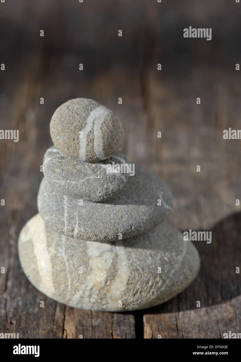 Piramide di pietre su legno simboleggiante zen, armonia, equilibrio Foto Stock