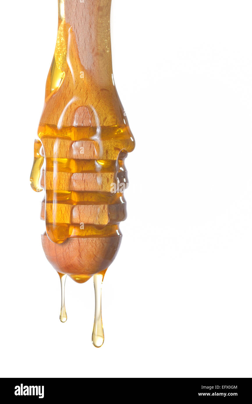 Il miele il gocciolamento da un miele di legno bilanciere Foto Stock