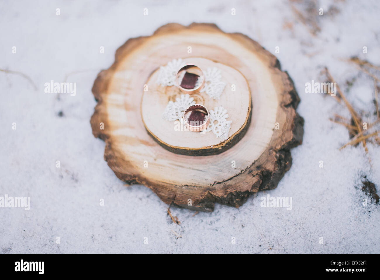 Gli anelli di nozze su un anello di supporto in fette di legno Foto Stock