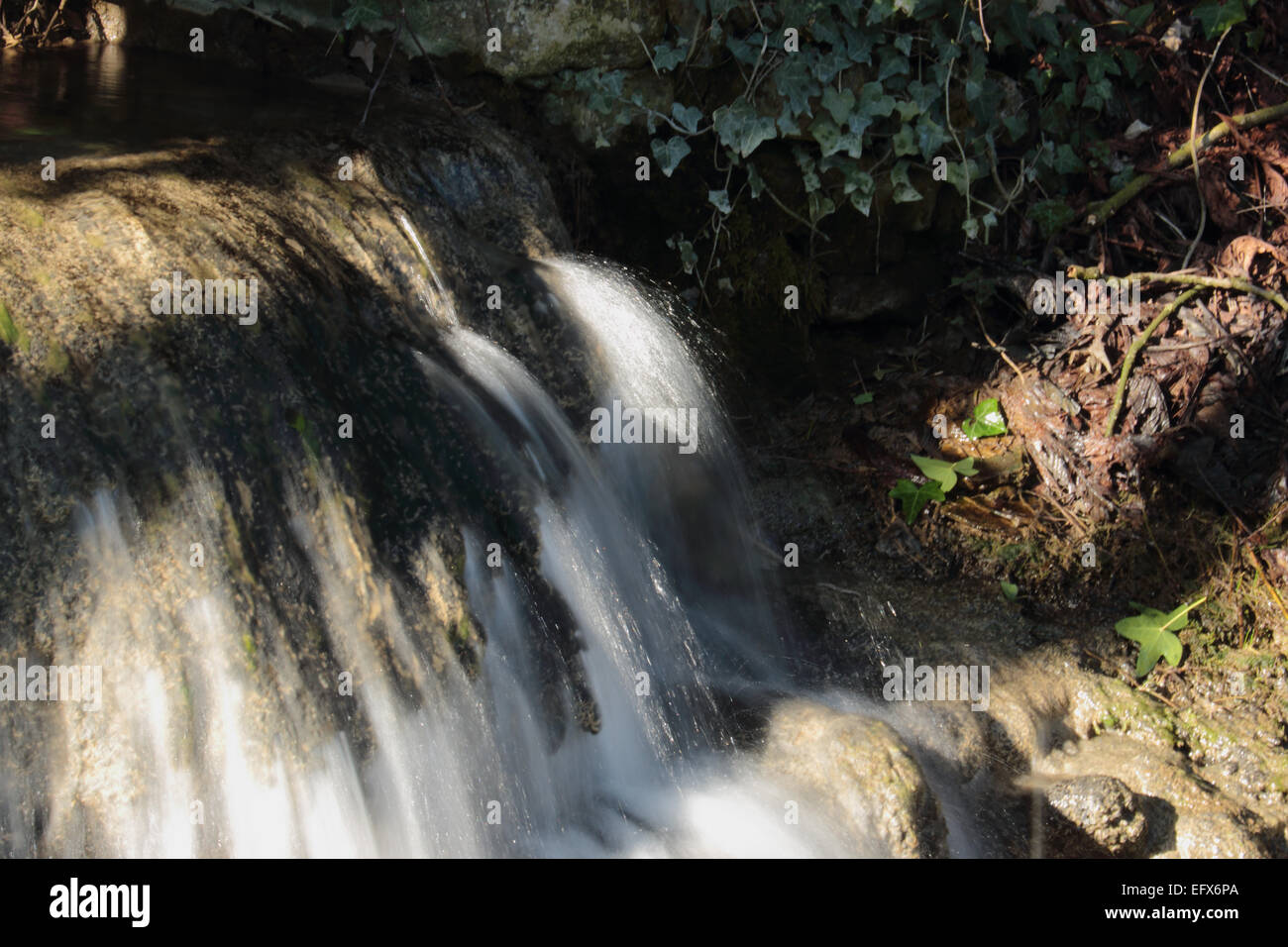 Flusso di spumanti e cascata che scorre attraverso il villaggio Foto Stock