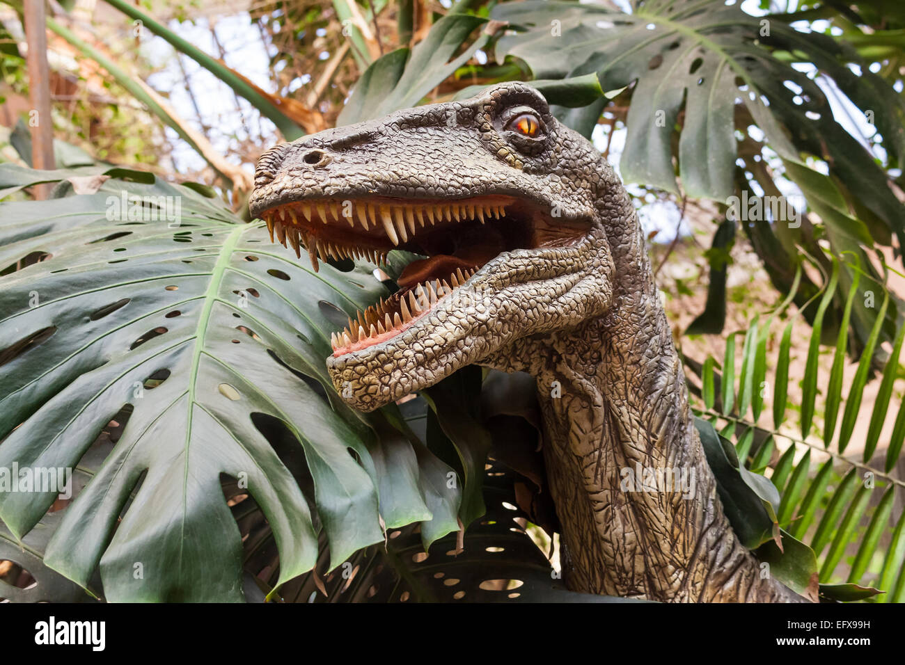 Ritratto di dinosauro figure in un parco boscoso Foto Stock